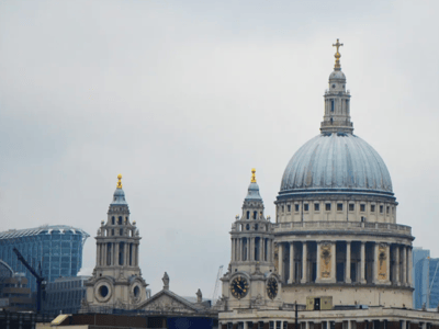 St. Paul's Cathedral, majestic with its imposing dome, overlooking the city of London under a cloudy sky.