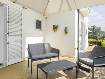 Welcoming outdoor space at Villa Rosaria, with modern furniture and touches of greenery against a bright and soothing backdrop.