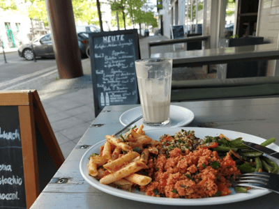 Délicieux plat à emporter avec pâtes, couscous et légumes, servi avec une boisson fraîche à Caramel.