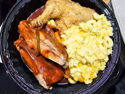 Crispy fried chicken, pork ribs, macaroni and cheese, and carrots, a comforting dish from Sylvia's in New York.