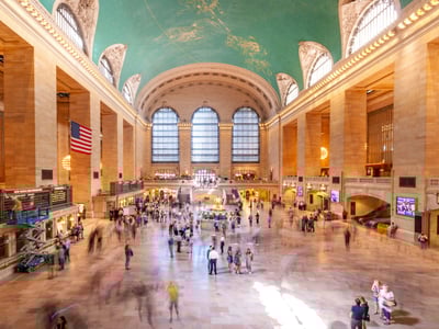 Spacious hall of Grand Central, featuring a decorated blue ceiling, welcoming travelers and tourists.