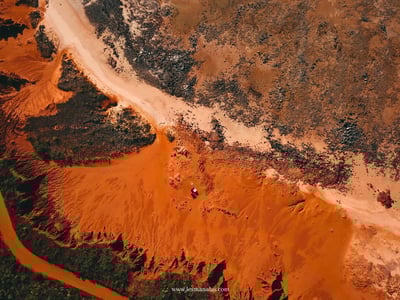 Aerial view of James Prices Point with red sands and a stretch of dry land, highlighting the natural beauty of the area.