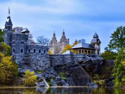 View of the Belvedere Castle in the heart of Central Park, surrounded by nature and imposing buildings in the background.
