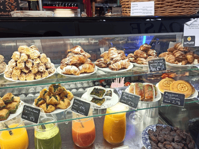 Étalage de pâtisseries et boissons colorées à Arminiusmarkthalle, un lieu prisé pour la gastronomie à Berlin.