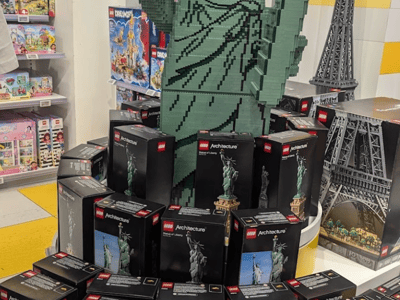 LEGO Statue of Liberty at the LEGO® Store Fifth Avenue, surrounded by boxes of iconic architecture models.