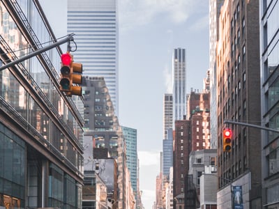 View of Lexington Avenue, with modern skyscrapers and lively urban traffic under a partly cloudy sky.