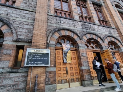 Main entrance of the Presbyterian Church of Ascension in Mount Morris, with wooden doors and posters about events.