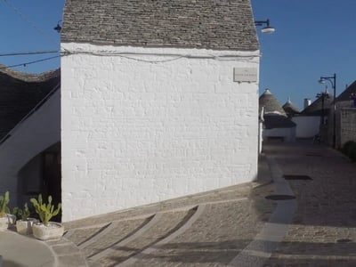 Une ruelle pavée à Quartier Monti, avec des maisons blanches et des toits de pierre, évoquant le charme traditionnel de la région.