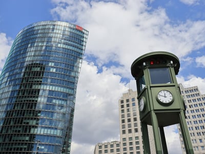 An impressive view of modernity at Potsdamer Platz with an iconic clock and a contemporary glass building.