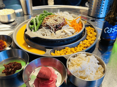 Délicieuse assiette de barbecue coréen avec viande marinée, légumes frais et accompagnements, servie au Han BBQ.
