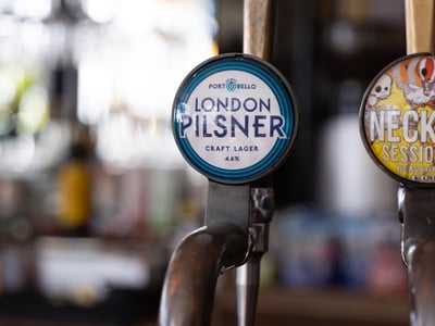 Artisanal beer tap displaying a London Pilsner label at the Prince Bonaparte bar in Paris.