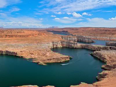 Lake Powell, majestic desert landscapes with turquoise waters and impressive rock formations under a blue sky.