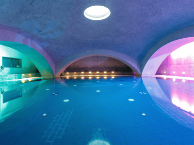 Interior of the Liquidrom, open-air pool with colorful lighting and modern domes, perfect for relaxation in Berlin.