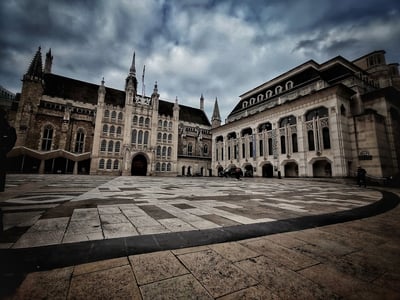 Vue des bâtiments historiques du Guildhall avec un ciel nuageux, témoignant du patrimoine architectural de Londres.