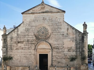 Historic church Chiesa della Madonna della Greca, featuring a stone façade and an ornate central rose window.