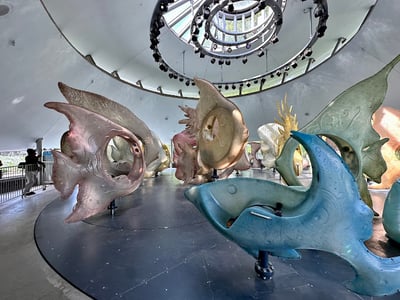 Montée d'une carrousel inspiré par la mer au SeaGlass Carousel, avec des créatures colorées et modernes sous une lumière magnifique.
