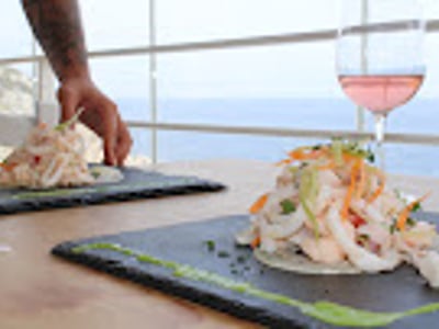 Delicious seafood dish, accompanied by a glass of rosé wine, with a view of the sea at L'Incanto.