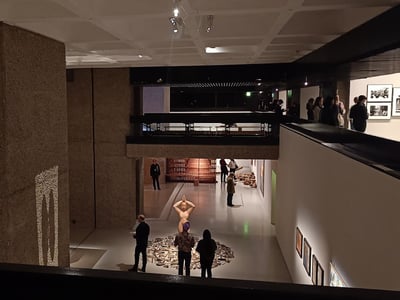 Interior view of the Barbican Art Gallery, where visitors admire contemporary artworks amidst modern architecture.