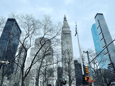 Impressive view of the Flatiron District with modern skyscrapers framing the famous Flatiron building and bare trees.