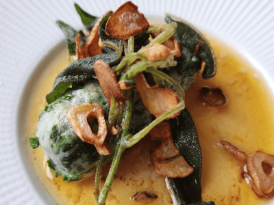 Fresh gnocchi with spinach, brown butter sauce, garnished with garlic chips, served at Ristorante A MANO.