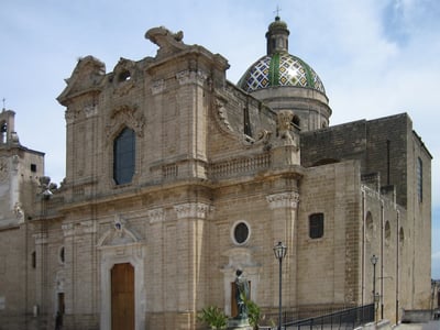 Colored dome and baroque facade of the Cattedrale Santa Maria Assunta a Cielo, which embodies Sicilian architecture.