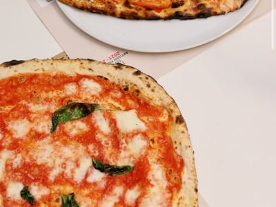Deux délicieuses pizzas napolitaines de l'Antica Pizzeria da Michele, garnies de tomates fraîches et de basilic.