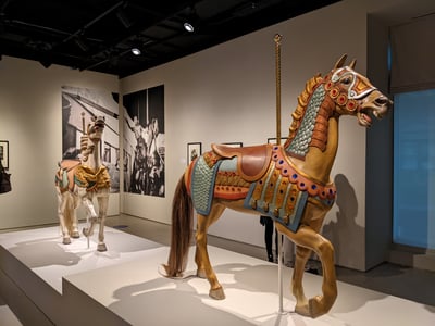 Colorful carousel horse sculptures exhibited at the Jewish Museum in New York, symbolizing art and culture.
