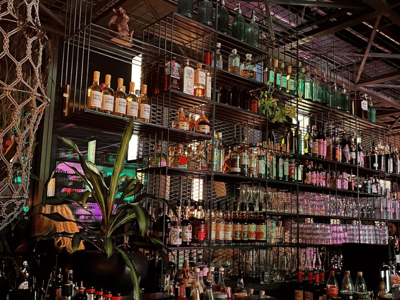 Bottle and glass shelf at the Monkey Bar, creating a lively atmosphere for enjoying refined cocktails.