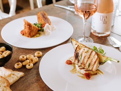 Délicieux plat de poisson grillé avec des garnitures élégantes, accompagné d'un verre de rosé au restaurant Dolce Vita.
