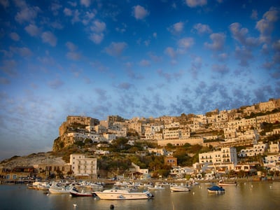 Panoramic view of Peschici, with its white houses perched on the cliff, surrounded by boats in the tranquil port.