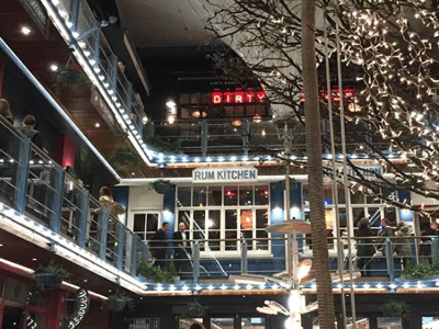 The lively interior of the Rum Kitchen on Carnaby Street, decorated with festive lights, with customers enjoying the friendly atmosphere.