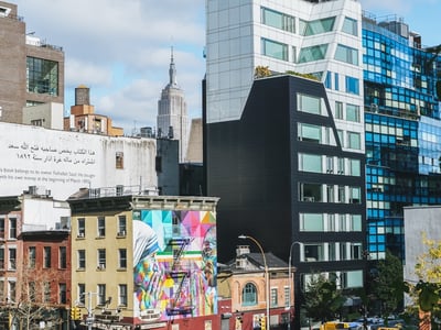 Vue colorée du High Line à New York, avec un mural vibrant et l'Empire State Building en arrière-plan.