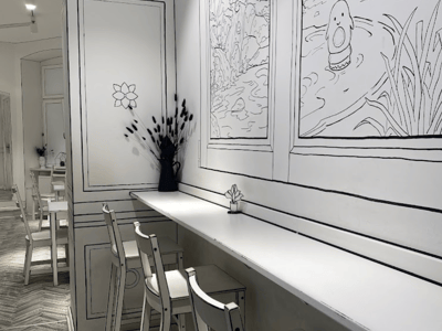 Modern interior of the 2D Cafe Always Together, with cartoon-style walls and an inspiring workspace.