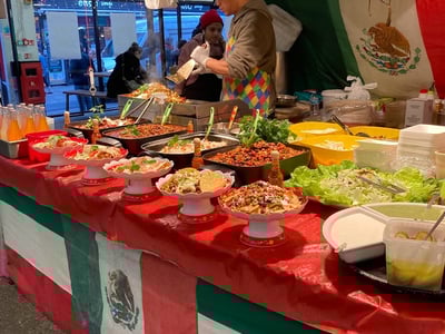 Un stand coloré aux marchés de The Truman Brewery, offrant une variété de salades mexicaines et de boissons rafraîchissantes.