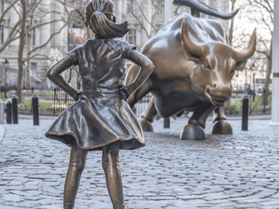 La jeune fille en bronze fait face au Taureau de Wall Street, symbolisant le pouvoir et la détermination à New York.