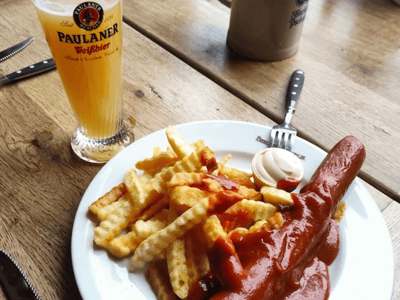 Grilled sausage with crispy fries and craft beer at Berliner Republik, a typical German meal.