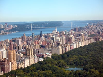 Vue panoramique de l'Upper West Side, avec le pont George Washington et la rivière Hudson, entourée de verdure.