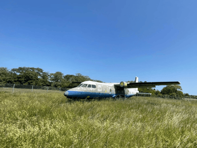 An abandoned old airplane on the grass of Tempelhofer Feld, symbolizing Berlin's aviation history.