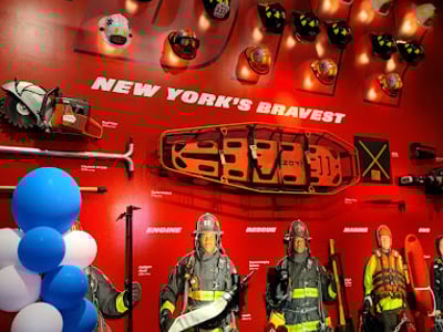 Uniformes et équipements des pompiers de New York exposés au FDNY Fire Zone, illustrant le courage des premiers intervenants.