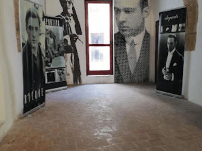 Entrance of the Rodolfo Valentino Museum, featuring portraits of the actor in a historical setting.