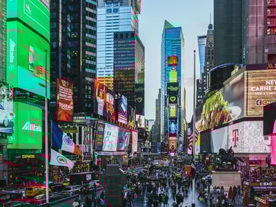 Vue animée de Times Square, illuminée par des écrans géants et remplie de piétons, symbole de l'énergie new-yorkaise.