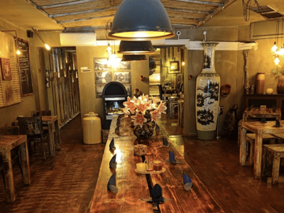 Intérieur chaleureux du restaurant Cao Cao, avec une grande table en bois et des décorations artistiques, parfait pour un repas convivial.