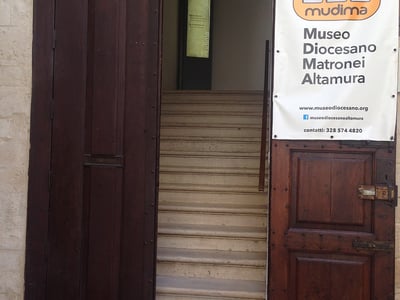 Entrance of the Museo Diocesano Matroneo in Altamura, with stairs leading to the religious art exhibition.