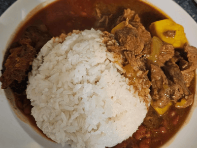 Delicieuse assiette de riz blanc accompagné de viande et de légumes dans une sauce savoureuse, typique de Zoralie.