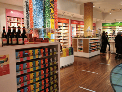 Magasin coloré de Ritter Sport Chocolate World, présentant des chocolats et bonbons en sachets sur des étagères bien décorées.