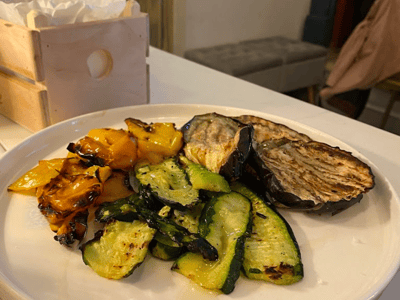 Grilled vegetable platter, including zucchini, peppers, and eggplant, served at Osteria Luce. A delicious plant-based option.
