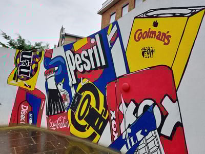 Grafisme coloré représentant des marques emblématiques sur un mur près du Museum of Brands à Londres.