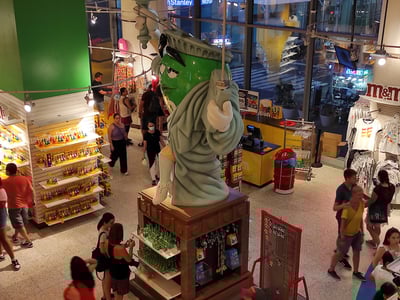 Statue de la Liberté en M&M's, entourée de clients admirant les bonbons et souvenirs colorés, à Times Square, New York.