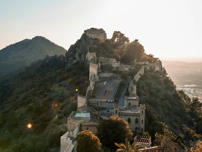 Historic castle of Xàtiva overlooking the valley, illuminated by the setting sun, symbol of the rich medieval heritage.