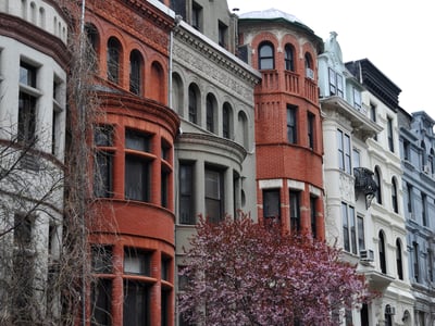 Architecture historique colorée sur l'Upper West Side, avec des bâtiments en briques et un cerisier en fleurs au premier plan.